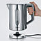A silver kettle floats above its base, held by a hand. A black handle and a viewing window can be seen.