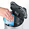 Hand wiping the inside of a kettle with a blue cloth, lid open.