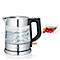 Glaswasserkocher mit kochendem Wasser, daneben Tasse Tee mit Himbeeren.