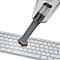 Close-up of a grey mini vacuum cleaner vacuuming a white keyboard. The bristles are red.