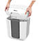 White paper shredder with its top being lifted by hands. The container is filled with shredded paper.