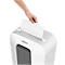 Person putting white paper into a white Fellowes shredder.
