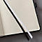 Notebook with graph paper pages and two bookmarks in black and white.