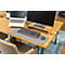 Schreibtisch mit Laptop, Monitor, Tastatur und Maus. Holzplatte, grauer Teppich. Bürostuhl im Vordergrund.