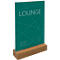 A green sign with the white lettering "LOUNGE" stands on a wooden base. Prices and other lettering are on the sign.