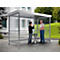 Two men stand under a shelter. One man points upwards, they seem to be talking to each other.
