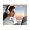 Junge Frau im Flugzeug, mit weiÃŸen KopfhÃ¶rern und Laptop am Fenster. Blick auf den Sonnenaufgang.