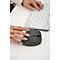 Une personne utilise une souris verticale et un clavier sur un bureau blanc. L'accent est mis sur la souris.