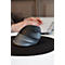 Une souris verticale ergonomique gris foncé sur un tapis de souris noir devant une personne travaillant sur un ordinateur.