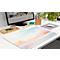 Bureau avec tapis de bureau coloré, design de clavier. Sur la table : moniteur, stylos, tapis de souris, plantes. Ambiance lumineuse et conviviale.