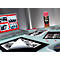 A workstation with a laptop, photos, adhesive spray, and CDs. The laptop displays images on a red interface.