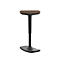 Standing stool with oval seat and black frame. The seat is brown.