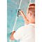 A man in a white t-shirt attaches blue insulation to a wall with a stapler.