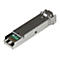 Metallfarbener SFP Transceiver. Mit grünem Chip und Schriftzug. Auf der Oberfläche sind kleine Details zu erkennen.
