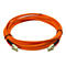 Orangefarbenes Glasfaserkabel in Form eines Kreises, mit zwei Steckern an den Enden.