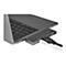 Graues Notebook mit einem USB-C-Hub, an dem Kabel angeschlossen sind.