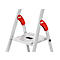 Close-up of a silver step ladder. Red handles with 'Hailo' lettering. Top step. Gray background.