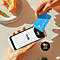 Person zahlt kontaktlos mit einer blauen Kreditkarte an einem mobilen Kartenlesegerät neben einem Teller mit Essen.