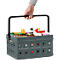 Person holding gray foldable shopping basket with products. Black handle. Basket is filled with groceries, such as mustard, jam and oil.