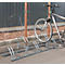 Vélo stationné dans un porte-vélos. Derrière le râtelier, un mur transparent et des supports bruns.