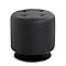 Pouf rond noir, rembourré avec capitonnage sur une base métallique brillante.