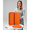 Une femme tenant un meuble orange pliable sur une table.