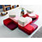 Multi-colored, modular sofa pieces; red, pink, and beige. On a white floor and gray carpet.