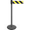 Gray bollard with black and yellow striped barrier tape. The bollard has a round base and a black top.