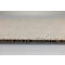 Gros plan sur le bord d'une moquette beige avec texture et sous-couche visibles.