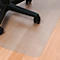Tapis de protection de sol transparent sous une chaise de bureau, sur un plancher en bois. Les pieds noirs de la chaise sont partiellement visibles.