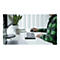 Un homme à un bureau avec une souris, un clavier et un moniteur. Il porte une chemise verte.