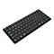 Schwarze, drahtlose Tastatur mit weißen Buchstaben und Ziffern. Die Tastatur liegt schräg auf einem weißen Hintergrund.