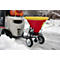 Forklift pulling a trailer with a salt spreader. On the trailer a red container with a yellow lid. Snow covers the ground.