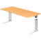 A height-adjustable desk with a light wood top and silver legs against a white background.