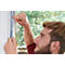 Ein Mann klebt Dichtung an ein Fenster. Der Blick des Mannes ist konzentriert. Die Hand des Mannes zeigt auf das Klebeband.