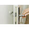 Gros plan sur une main ouvrant une porte avec une poignée argentée.