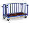 Blue transport trolley with brown loading area and grids. It stands on four wheels. Handle and grids protect the load.