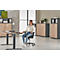 Jeune femme au bureau, assise à son bureau. Elle est assise sur une chaise de bureau. Il y a un ordinateur portable sur la table.