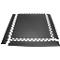 Black rubber floor tiles with white tooth edges forming a rectangle. A few pieces can also be seen on the edge.