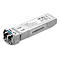 Ein silberfarbener TP-Link SFP+-Transceiver. Der Stecker hat einen blauen Einsatz. Auf dem Gehäuse befinden sich Aufkleber mit Informationen und Logos.