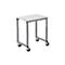 A white height-adjustable table with wheels against a white background.