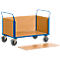A blue transport trolley with wooden sides and four wheels. A loose wooden board is lying under the trolley.