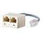 Ein beigefarbener Telefonanschluss-Splitter mit zwei Buchsen und einem grauen Kabel, das zu einem transparenten RJ45-Stecker fÃ¼hrt.