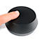 Bouton noir, doigt touchant la surface.
