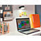 Laptop auf weißem Schreibtisch, beleuchtet von einer schwarzen Lampe. Orange Ordner und Haftnotizen daneben.