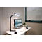 Schreibtisch mit Lampe, Monitor, Laptop und Pflanze. Helles Büro mit Fenster und Jalousie.