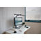 Schreibtisch mit Monitor, Tastatur, Lampe und Pflanze vor Holzpaneelen.