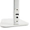 Close-up van een witte bureaulamp met USB-poort en stroomaansluiting. De lamp staat op een rechthoekige basis.