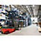 Forklift in a warehouse; high shelves filled with goods; bright lighting.