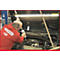 Mechaniker in rotem Overall von KS TOOLS arbeitet an einem Motorraum. Werkzeug im Einsatz.
